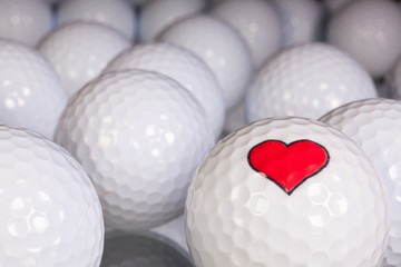 Golf balls with love symbol on the black glass table