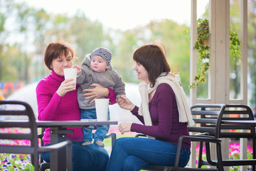 Fototapeta na wymiar Grandmother, mother and little son in cafe