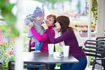 Grandmother, mother and little son in cafe