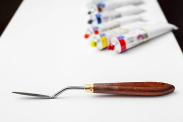 palette knife closeup and oil multicolor paint tubes on white ar