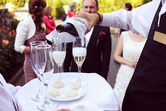 Waiter serving champagne on a tray wedding