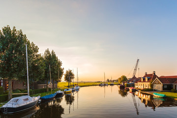 Fototapeta na wymiar River with sailing boats in the Dutch province of Friesland