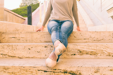 Ballerina sitting on step in shoes