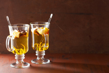glass of mulled apple cider with orange and spices, winter drink