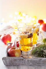 glass of mulled apple cider with orange and spices, christmas de