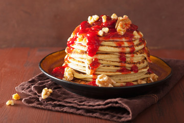 stack of pancakes with strawberry jam and walnuts. tasty dessert