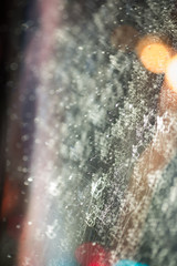 Drops of rain on window with abstract lights