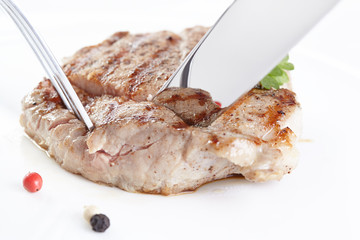 Grilled steak on white plate closeup