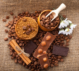 Coffee beans in wooden bowl on burlap tablecloth, rustic style