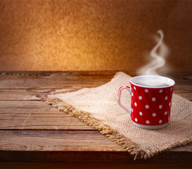 Coffee cup and saucer on  wooden table.