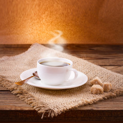 Coffee cup and saucer on  wooden table.