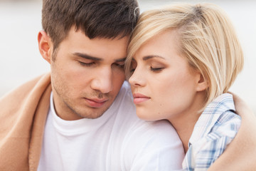 Attractive young couple standing on beach at summer.