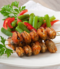 Fried mussels with onions on skewers c garnish of green beans an