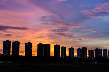 row of condominiums at sunset with multicolored sky