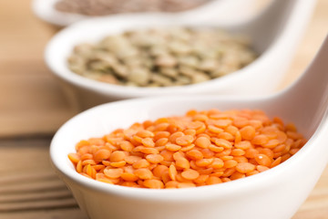 Three kinds of lentil in bowls - red lentil, green lentil and br
