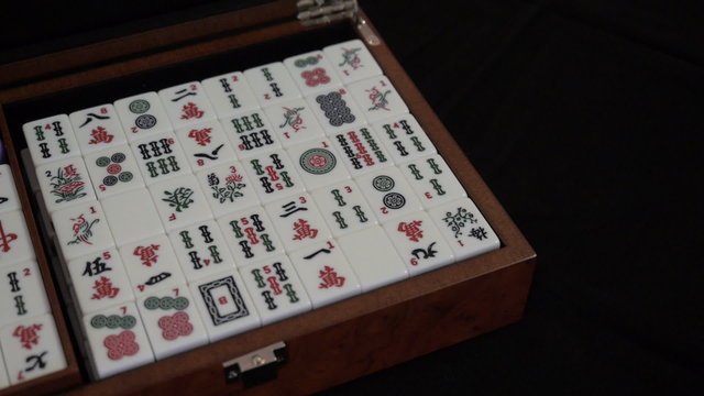 Mahjong. Opening the lid of box.