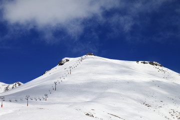 Fototapeta na wymiar Ropeway and ski slope in sun day