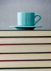 Blue coffee cup on stack of books