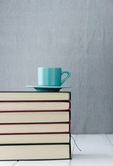Blue coffee cup on stack of books