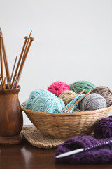 Knitting needles and yarn balls in basket