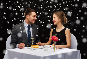 smiling couple eating dessert at restaurant