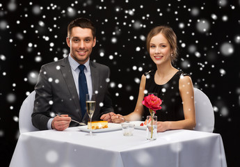 smiling couple eating dessert at restaurant