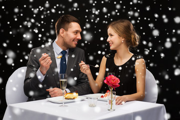 smiling couple eating dessert at restaurant