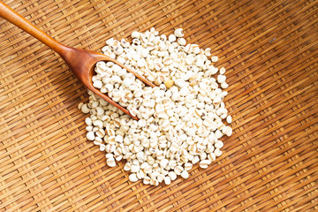 Millet (grain) in spoon on wooden.