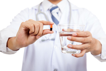 Asian male doctor with a capsule and water