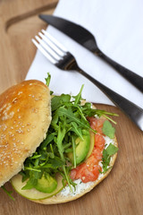 Hamburger with avocado, smoked salmon, apple and green salad
