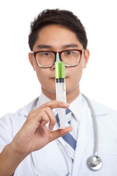 Asian male doctor hold syringe with green medicine