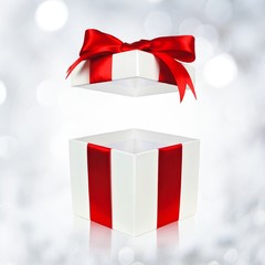 Open red and white gift box on twinkling background