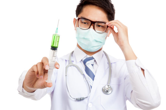 Asian male doctor  wear mask thinking focus at  syringe
