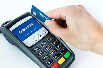 Hand with credit card swipe through terminal for sale. Enter PIN