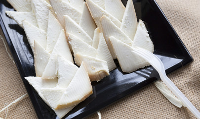 slices of cheese on a serving dish with a plastic fork