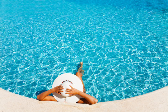 Lady with white hat laying in the blue water