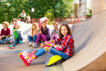 Girl wears in-line skates sits in front with mates