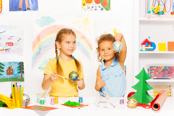 Naklejka premium Girls painting New Year balls for Christmas tree