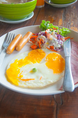breakfast with fried eggs, toasts, juice and salad