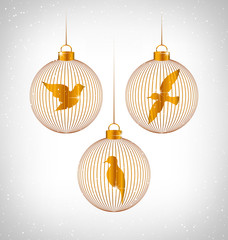 Golden Birds in golden Christmas balls in snowfall on grayscale