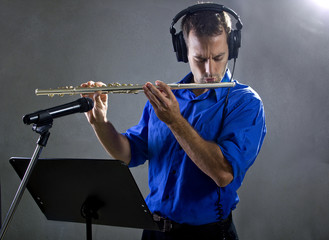 male flute player in a recording studio with headphones © Innovated Captures