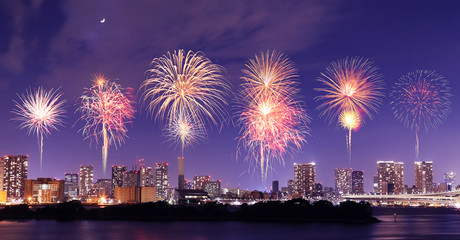 Naklejka premium Fireworks celebrating over Tokyo cityscape at nigh