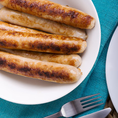 Freshly cooked chicken sausages in a white bowl