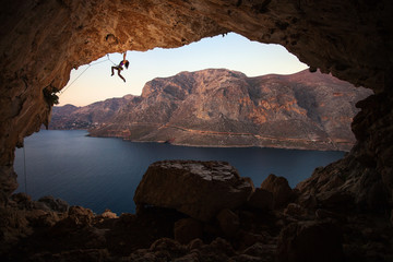 Female rock climber on cliff in cave at Kalymnos, Greece