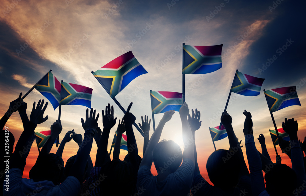 Wall mural People Waving South African Flags in Back Lit