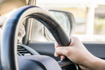 Close-up of a woman hand on a steering wheel