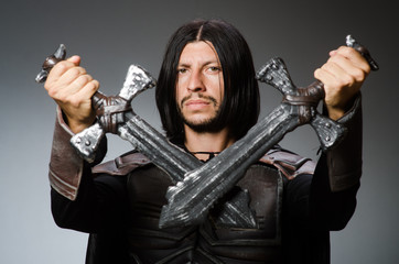 Angry knight with sword against dark background