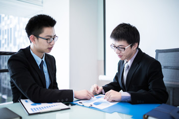 Two Businessmen Having Informal Meeting In Modern Office
