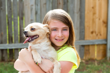 Blond kid girl with chihuahua pet dog playing