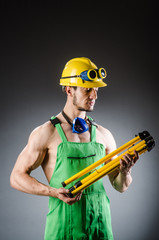 Ripped muscular builder man with tools